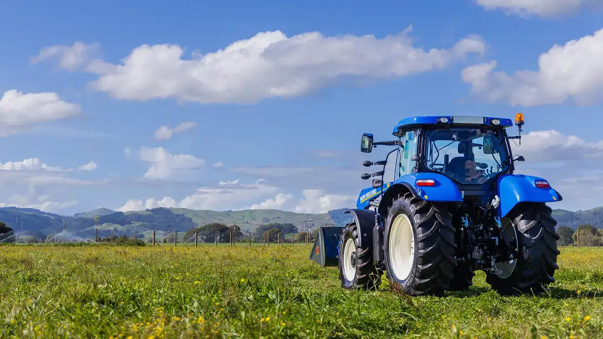 New Holland T6000 Tier 3 tractor sitting in New Zealand field, with loader configuration