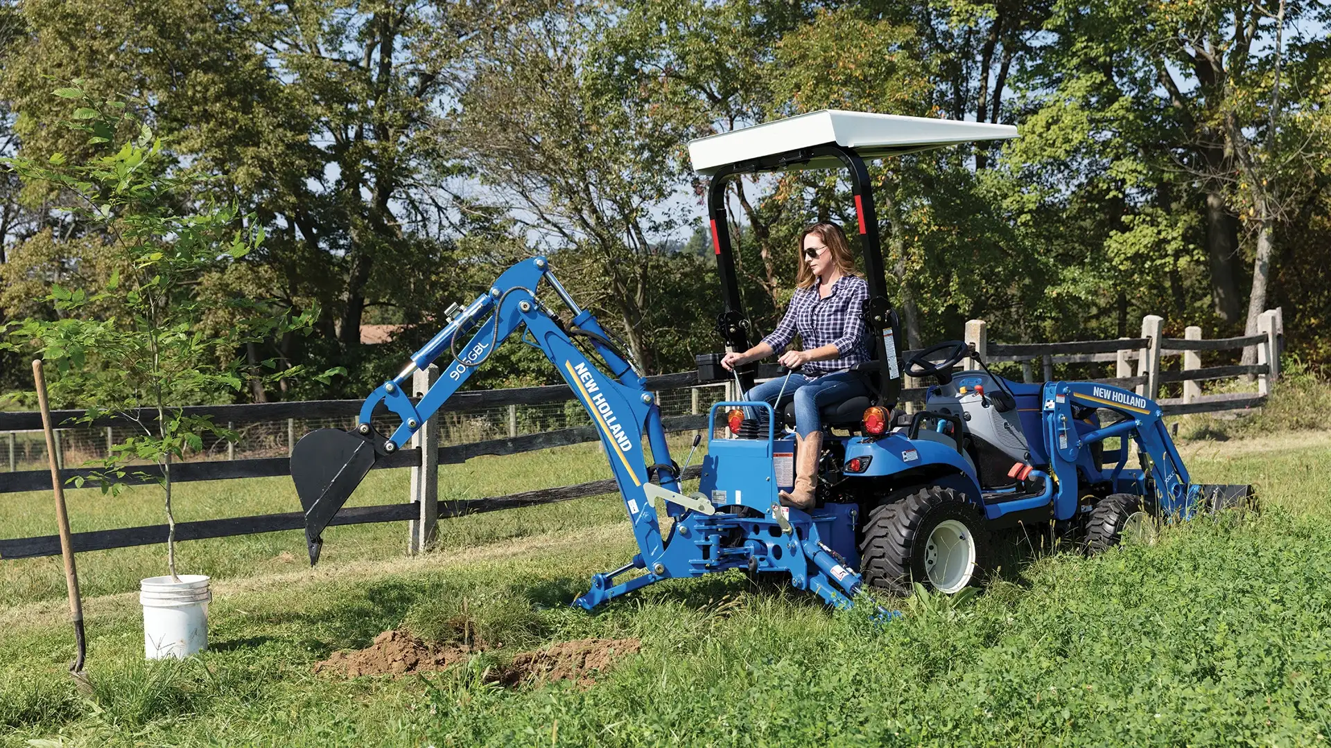 Woman uses backhoe attachment on the WORKMASTER 25S tractor