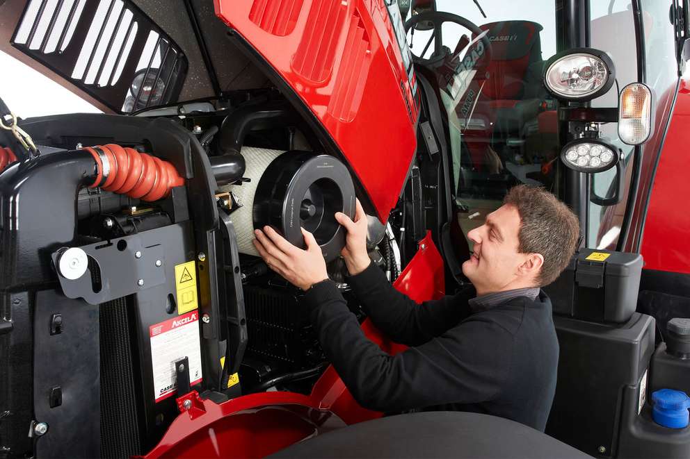 Man replacing filter on Case IH tractor machine