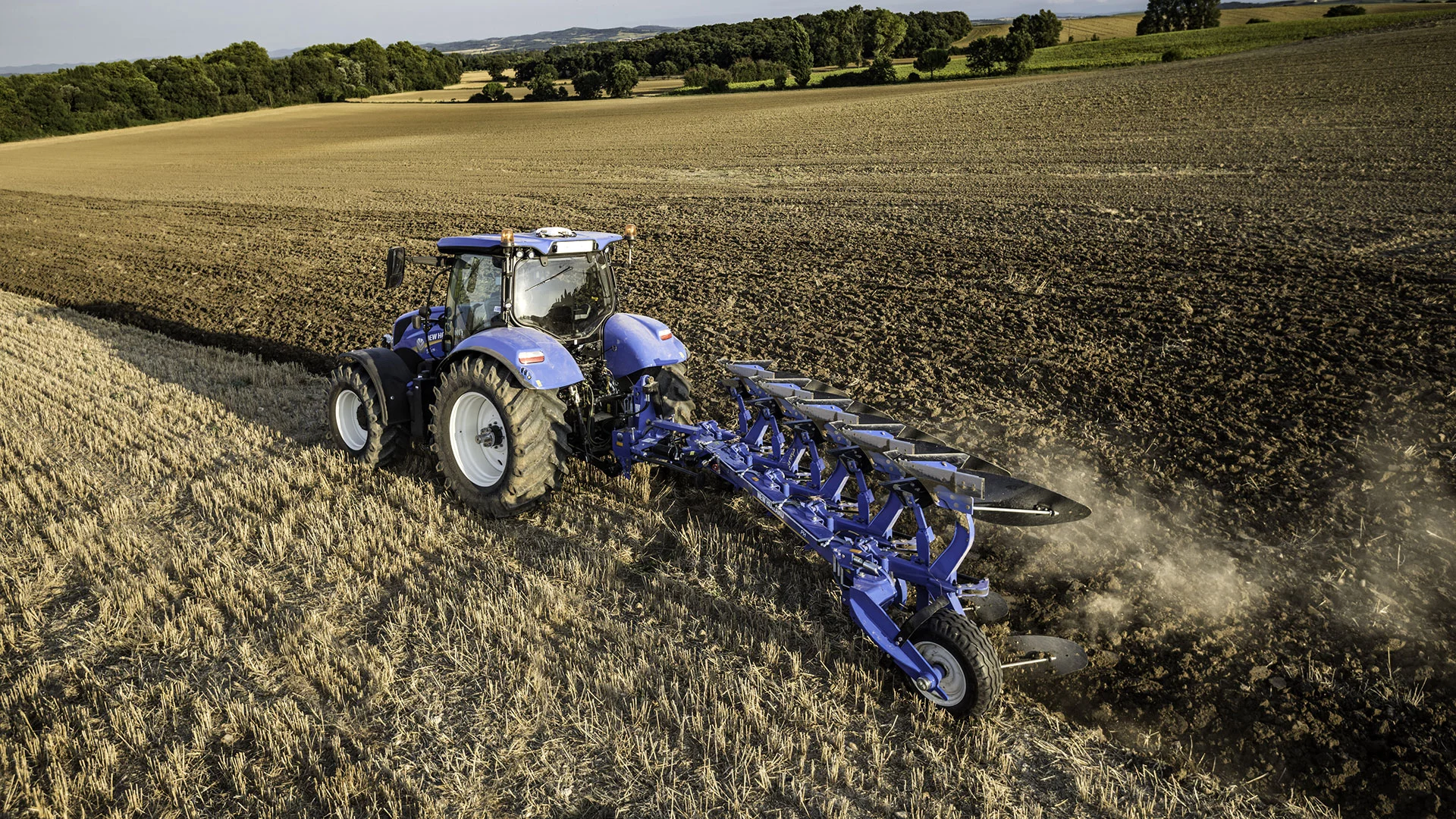 Tractor with a 5 furrow fully-mounted plough working on the field