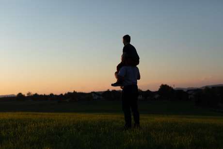 a man and a kid at sunset