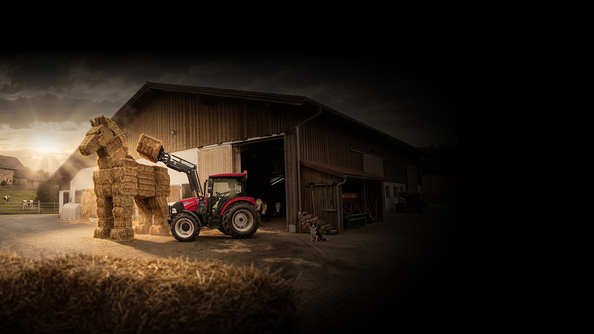 Case IH Traktor mit Frontlader baut eine Pferdeskulptur aus Strohballen vor einer Scheune