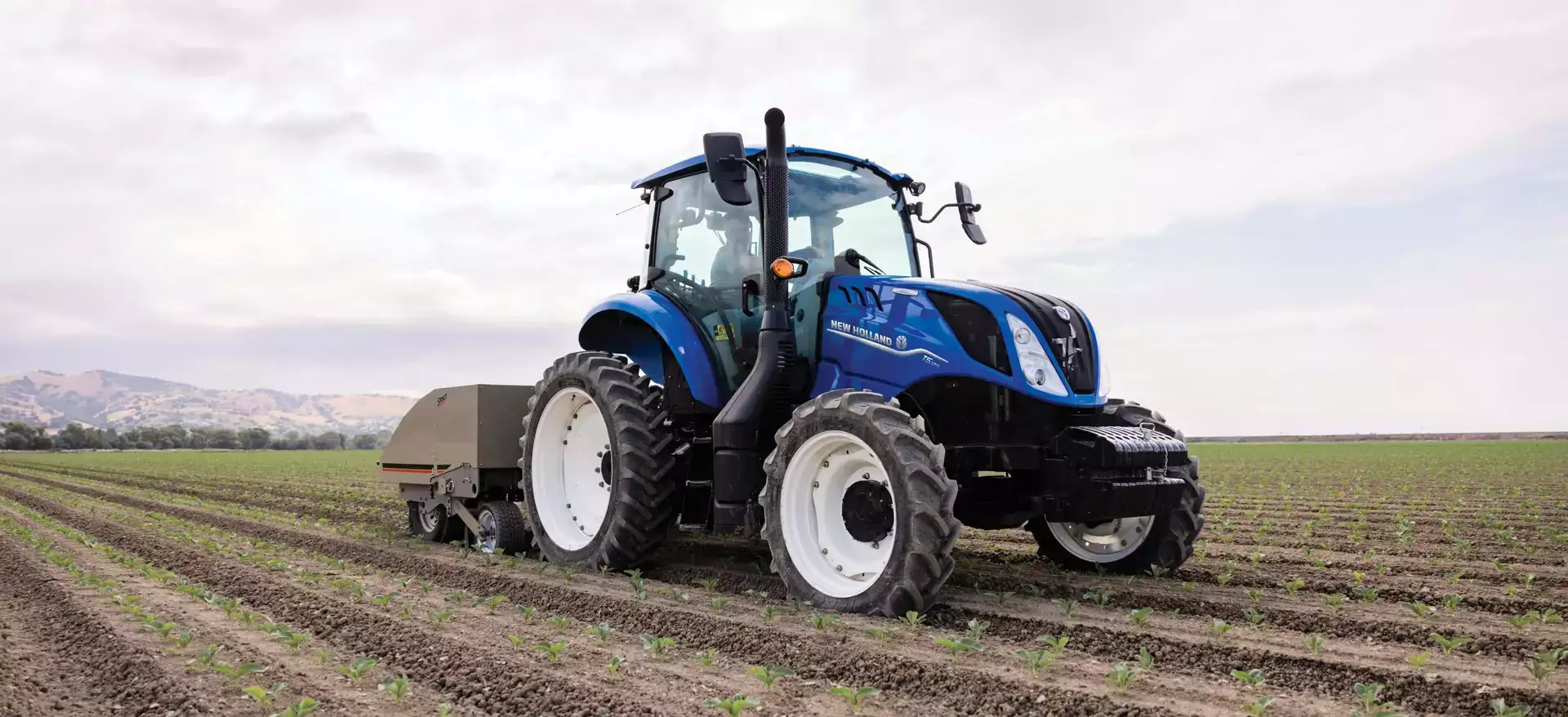 T5 Series tractor pulls a cultivator