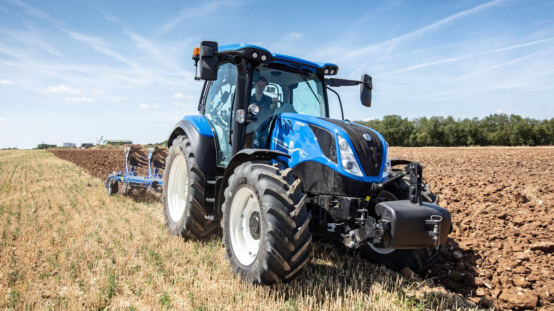Farming tractor New Holland T5 Dynamic Command & Auto Command in action on agricultural land