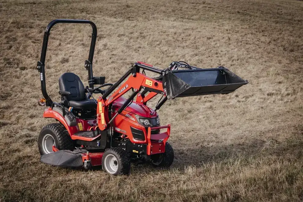 Farmall Subcompact tractor sitting in field with front loader
