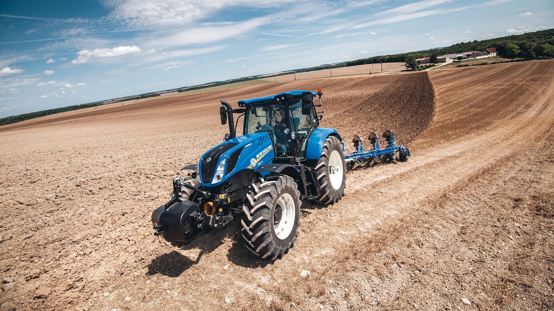 New Holland T5 Dynamic Command & Auto Command tractor with a plough working on the field