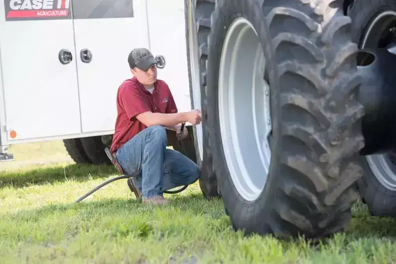 technician checking tractor tire pressure