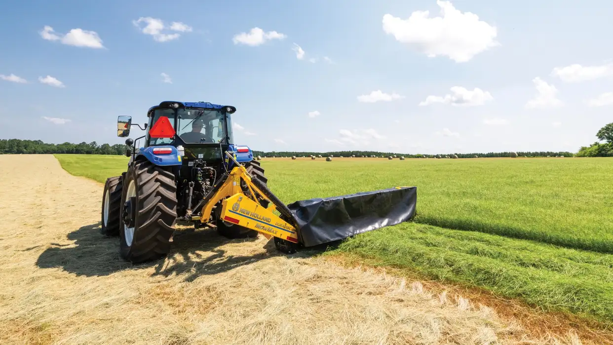 New Holland tractor pulling disc mower.