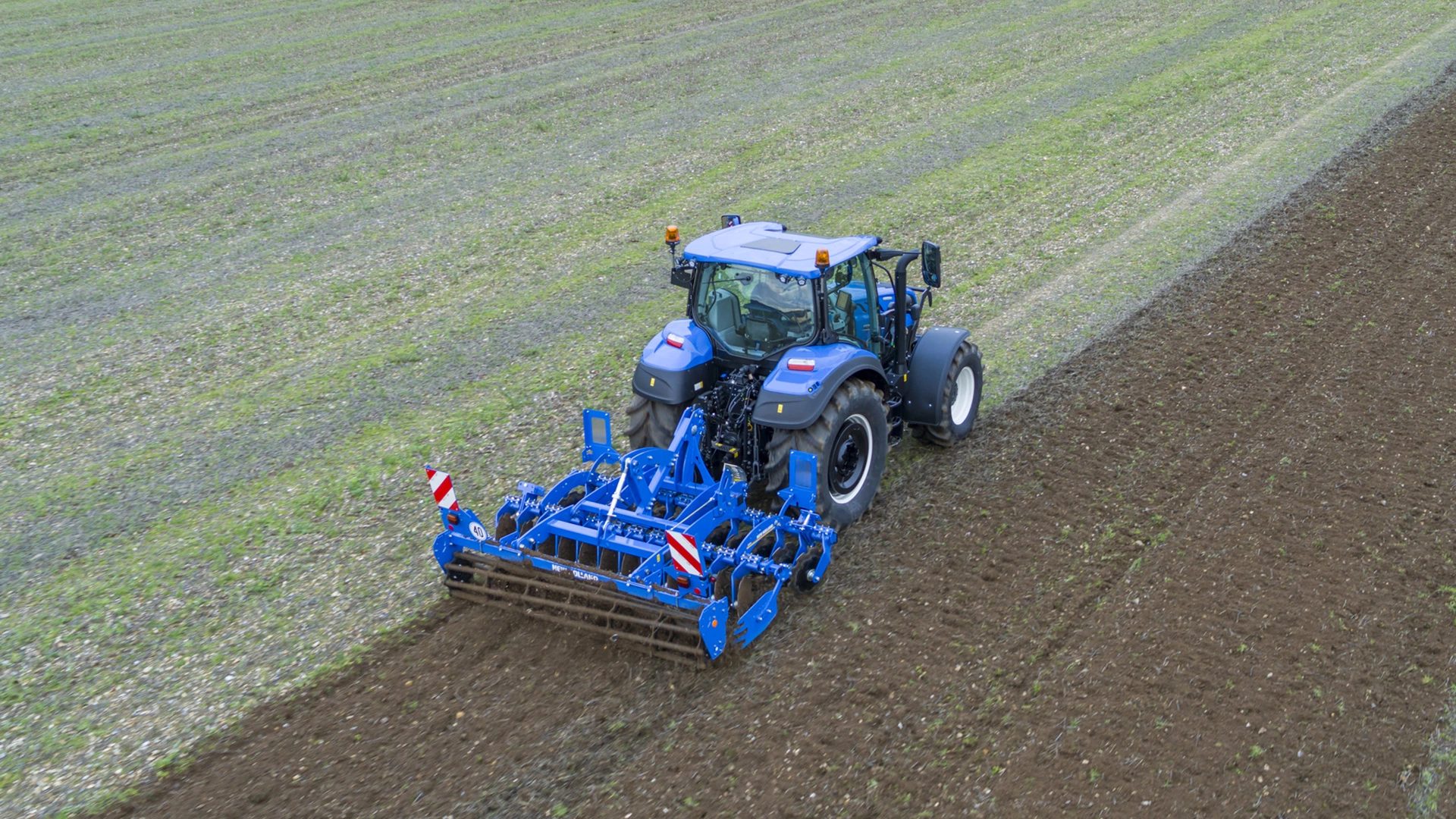 Tillage operation in progress with SDM & SDH Disc Cultivators mounted on a New Holland tractor