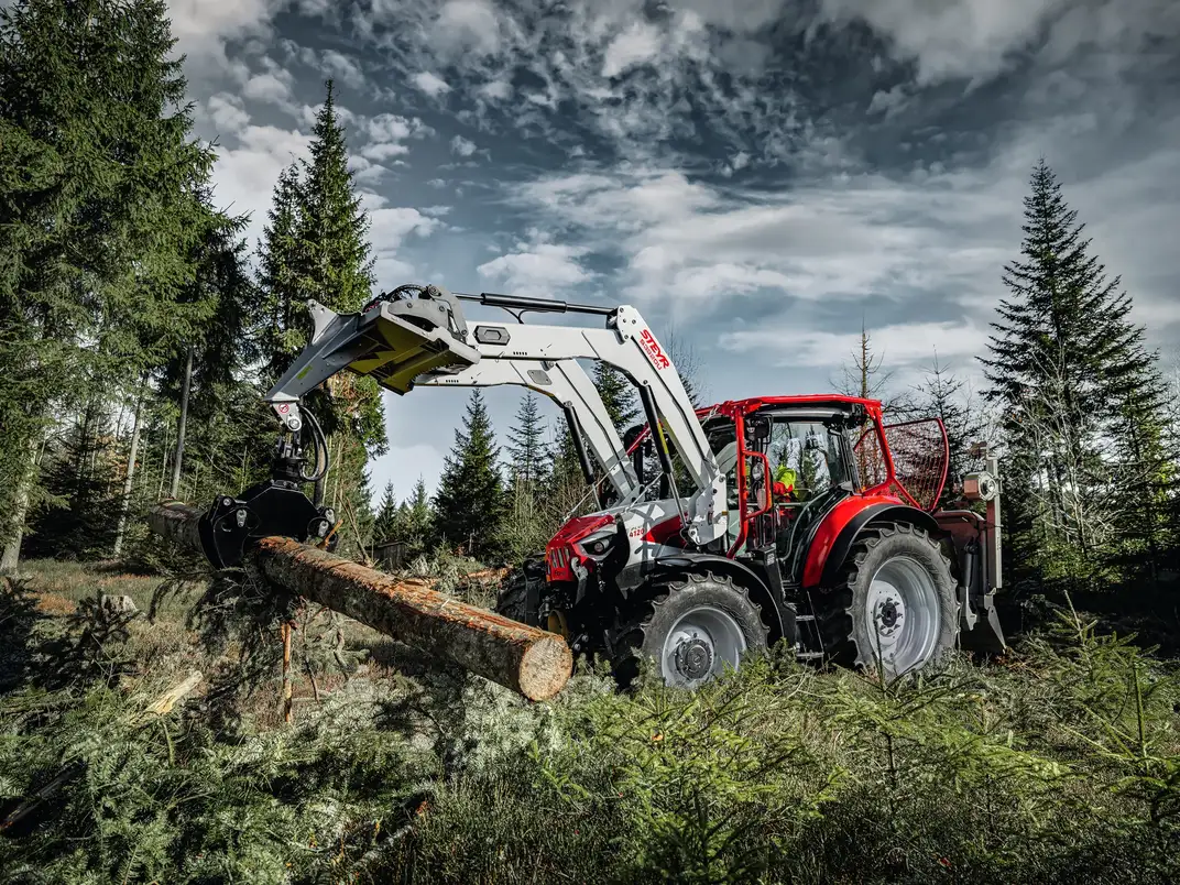 Trattore forestale STEYR rosso con gru per la movimentazione di tronchi nel bosco