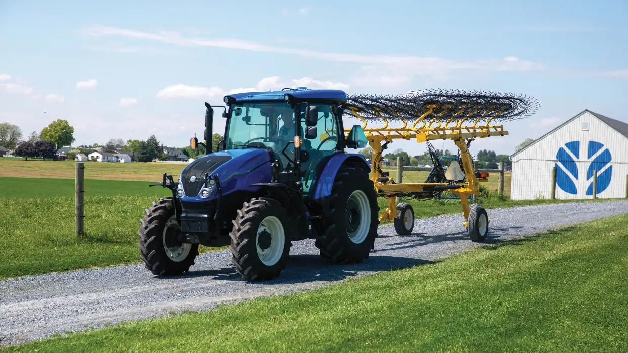 WorkMaster tractor pulling hay rakes.