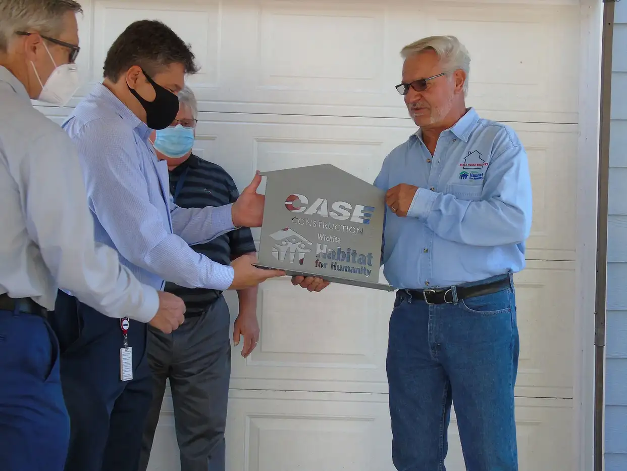 Bill-Bauck-Wichita-Habitat-for-Humanity-Board-member-presents-a-plaque-to-CASE
