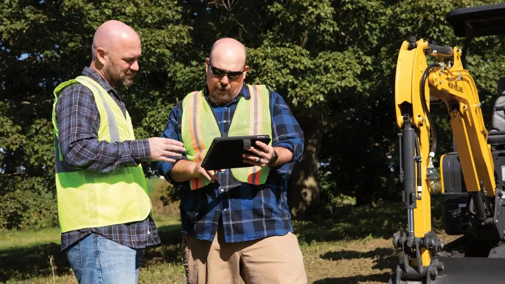 Operators check equipment on a tablet using FleetForce telematics