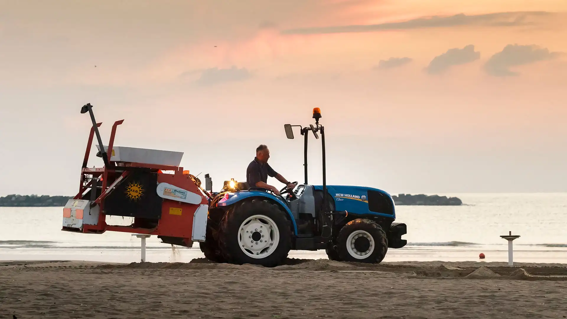 Man operates T3F Compact Specialty tractor on a beach