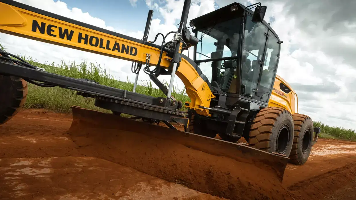 foto ao ar livre da Motoniveladora New Holland Construction em operação, com destaque para a sua lâmina