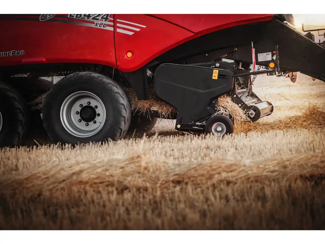 Close-up of the Case IH LB424 XLD large square baler pick-up mechanism collecting straw in a stubble field