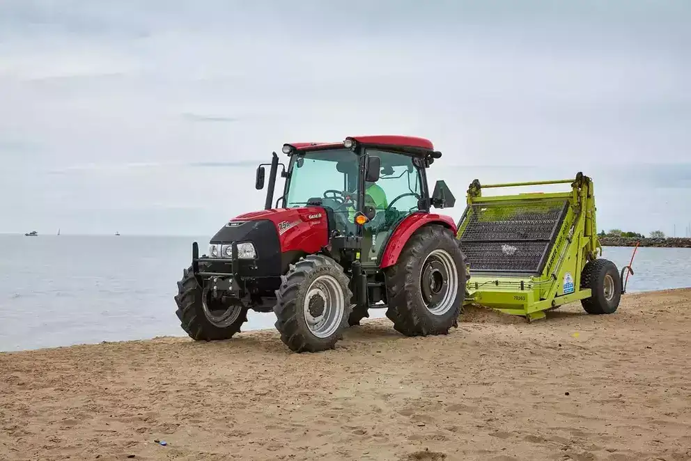 Case IH Farmall Utility 75 A pulling equipment on beach