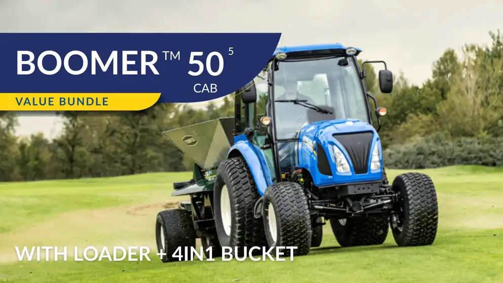 New Holland Boomer 50 cab tractor sitting in field with operator