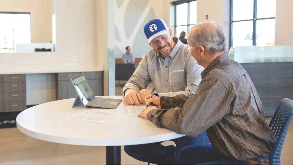 A dealer talks to a customer at a New Holland dealership