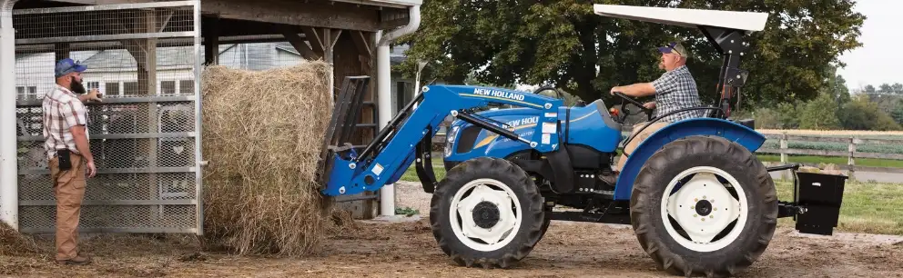WorkMaster™ 60 tractor lifting hay bales.