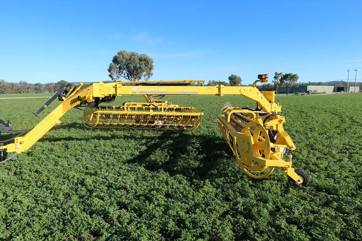 New Holland rolabar rake, roller bar working in field with New Holland tractor in Australia