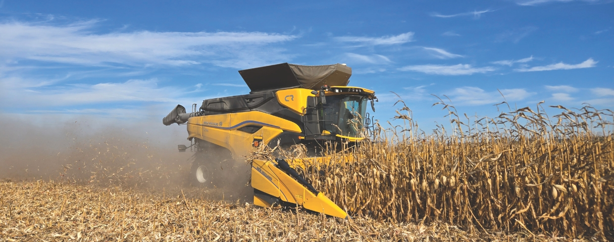 New Holland combine with corn header in the field