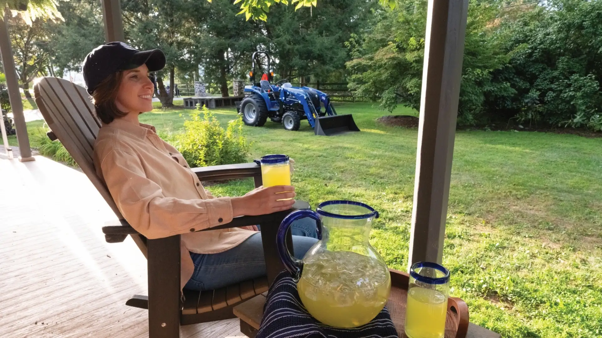 Women drinking lemonade on porch in front of Tractor.
