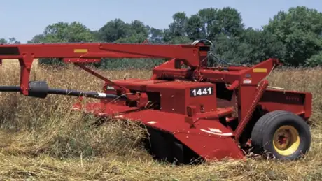 Red disc mower-conditioner in a field.