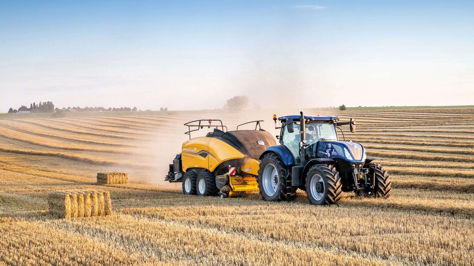 Tractor in action, operating a Bigbaler Plus Square Baler on an expansive agricultural field