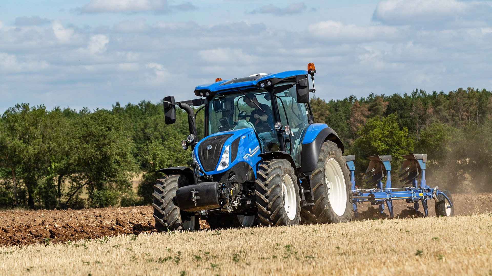 New Holland T5 Dynamic Command & Auto Command agricultural tractor actively engaged in agricultural field work