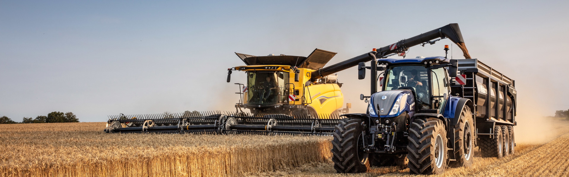 Yellow New Holland CR combine harvesting in field, whilst releasing seeds