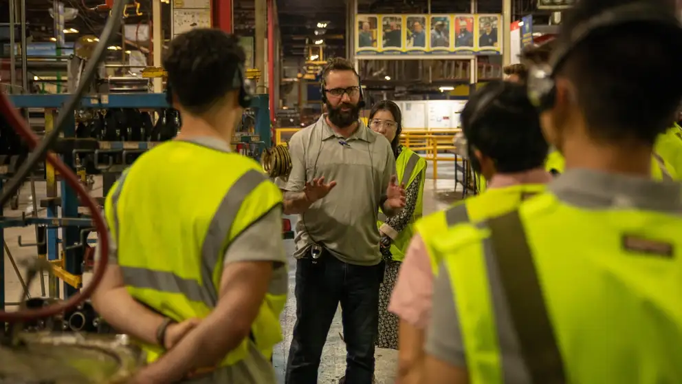 Tour guide leads group though the New Holland factory