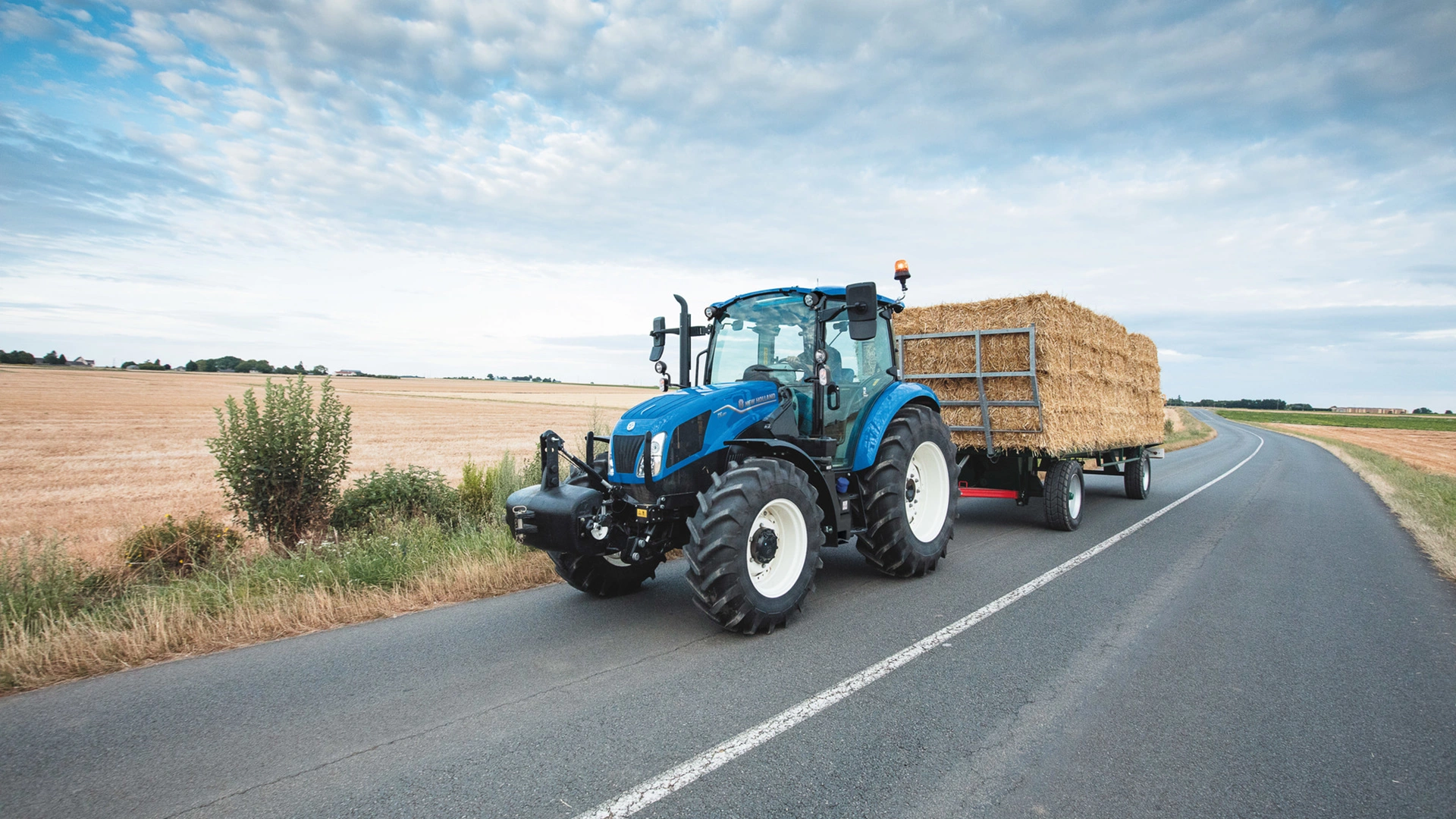 Farm goods transportation underway with New Holland T5 Utility agricultural tractor