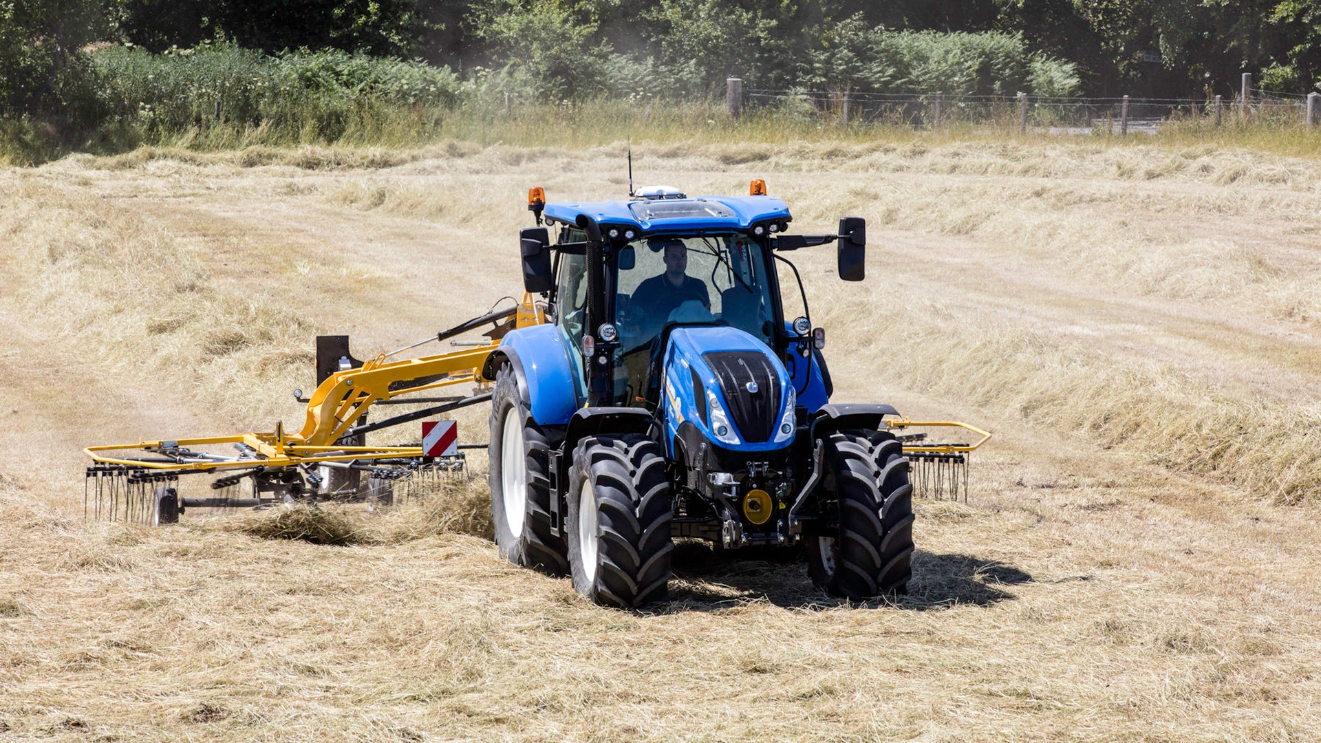 Tractor with Prorotor C Twin Rotor Rake working on the field