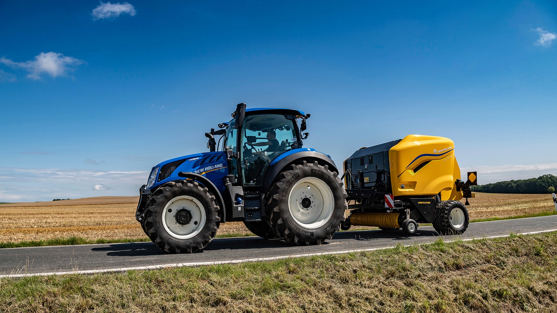 New Holland Tractor with Roll Bar 125 round baler.