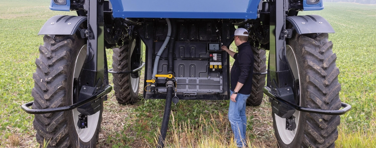 Man reaches service point under the Guardian Front Boom Sprayer