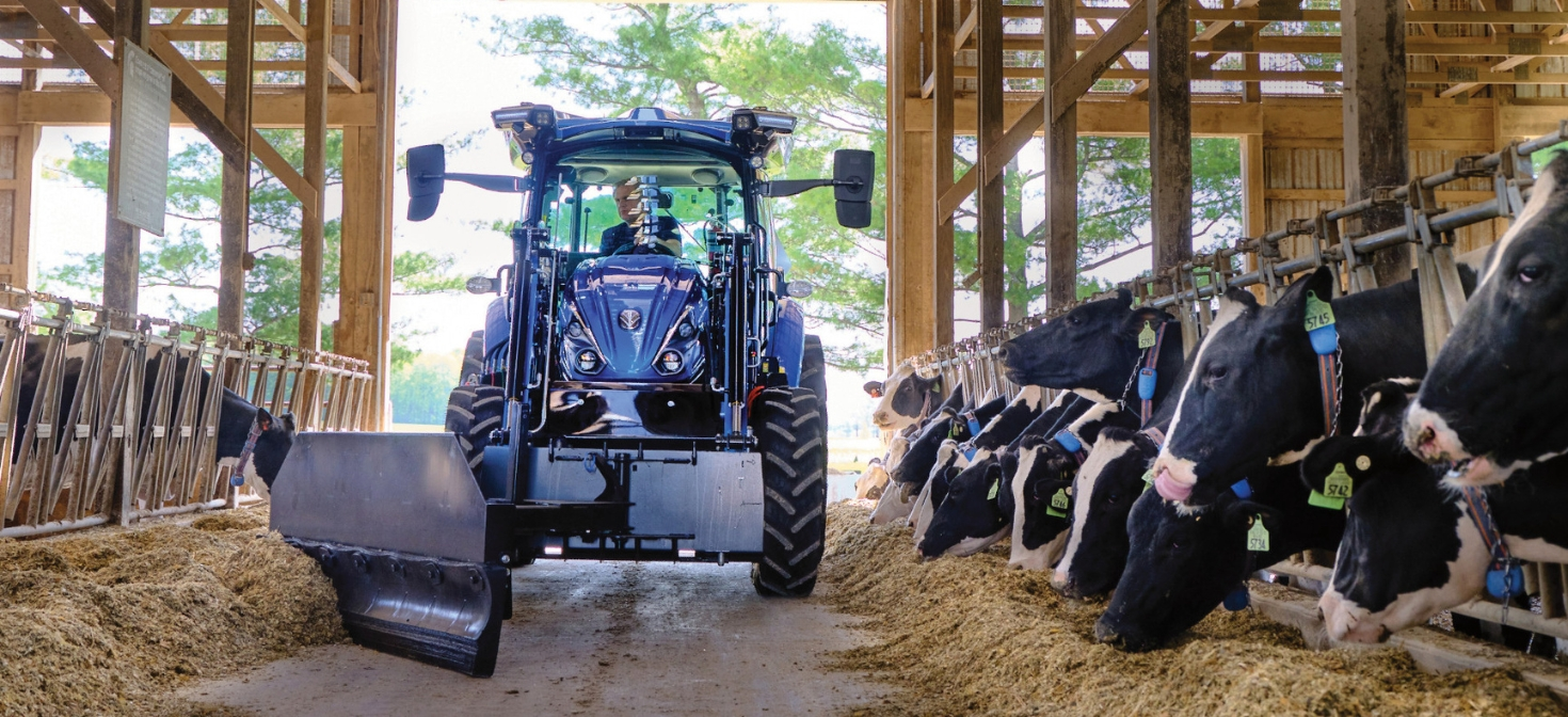 T4 Electric Tractor using implement in barn with cows