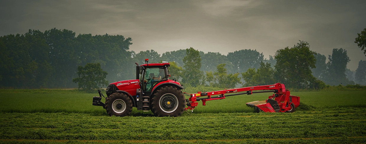 A Puma 260 tractor with a DC165 mower working a field.