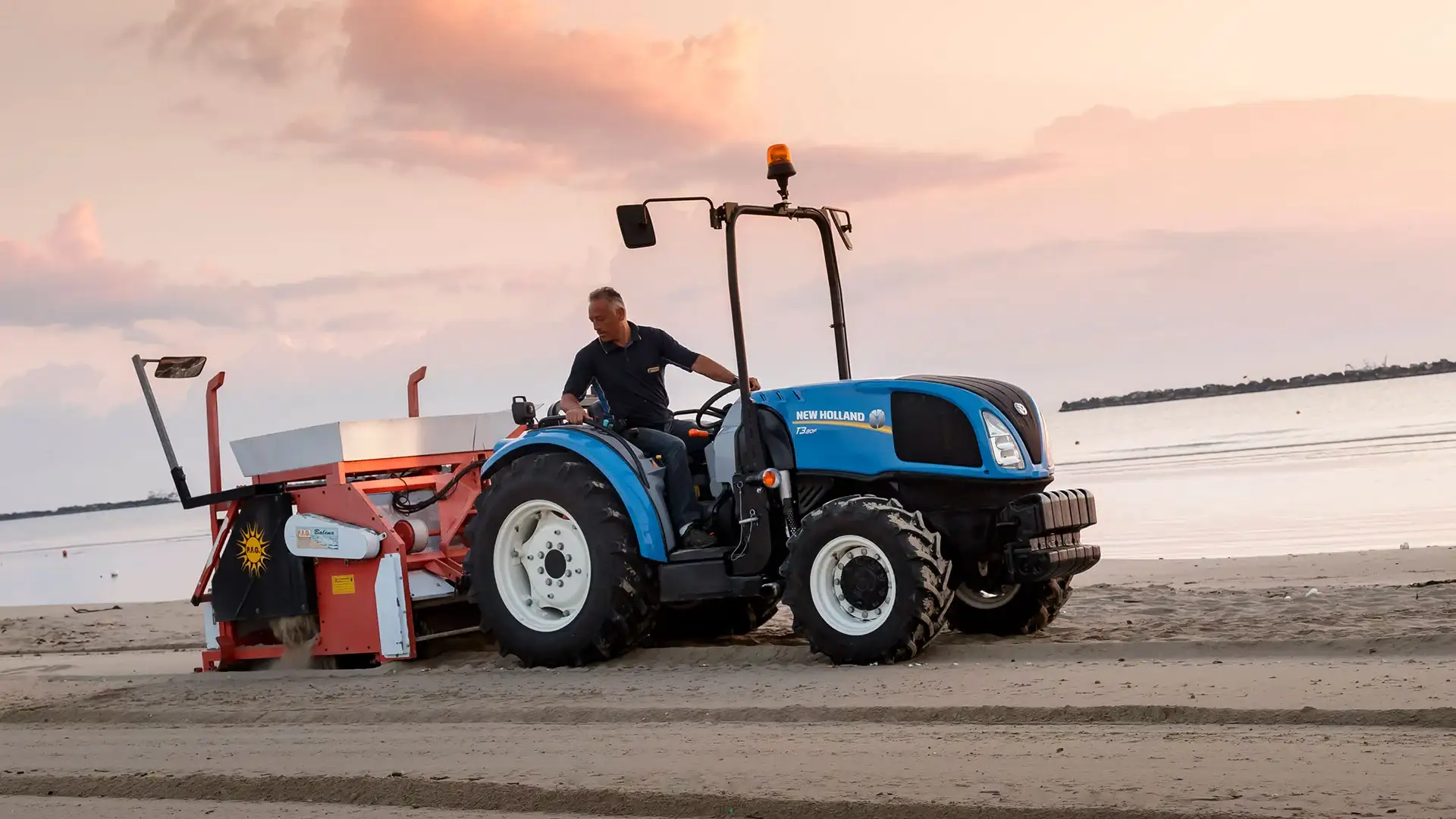 Man operates T3F Compact Specialty tractor on a beach