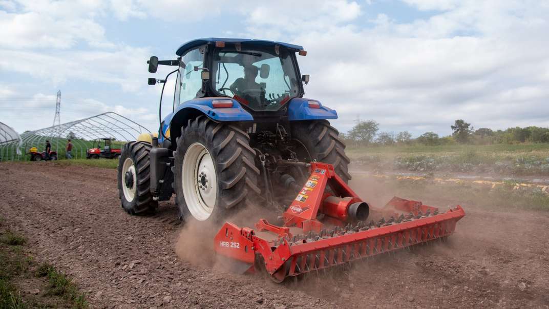 Back profile of New Holland Tractor in a field.