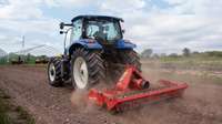 Back profile of New Holland Tractor in a field.