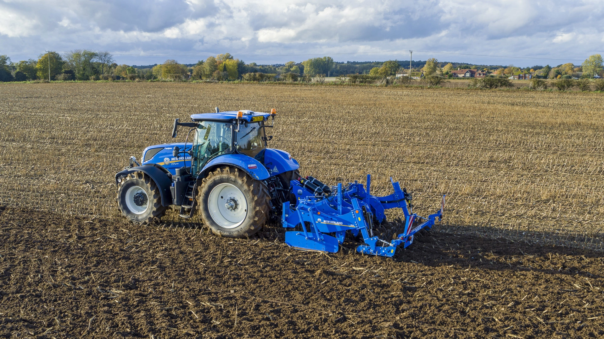 New Holland tractor utilizing SUM & SUH Subsoilers for deep soil aeration and conditioning on agricultural field