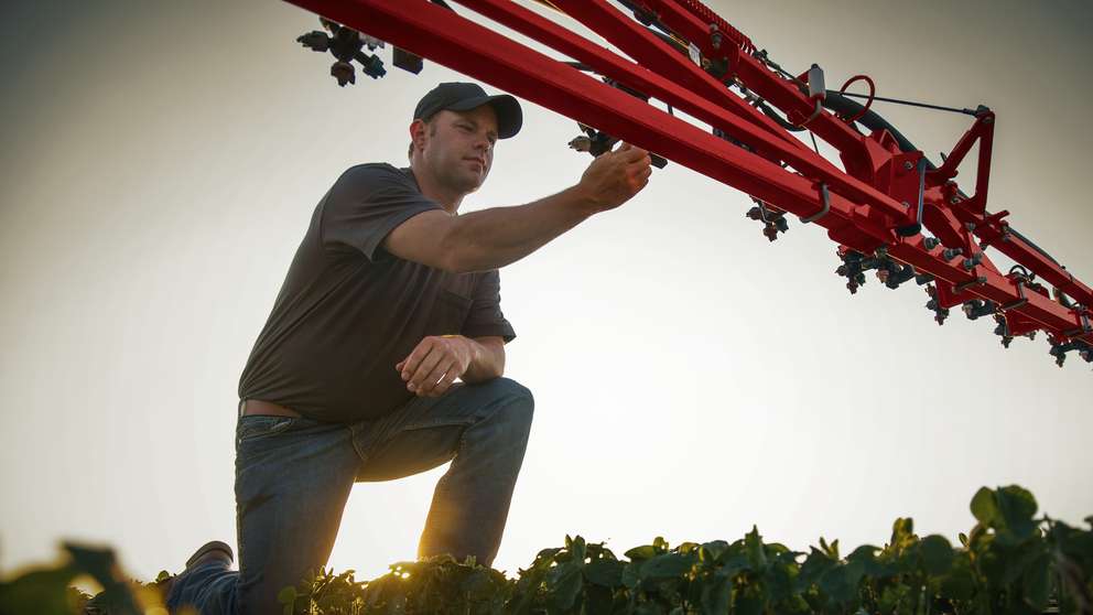 Producer adjusting sprayer nozzles