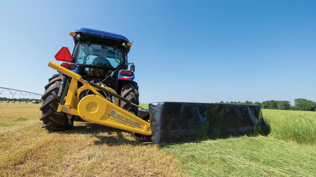 New Holland tractor pulling disc mower.