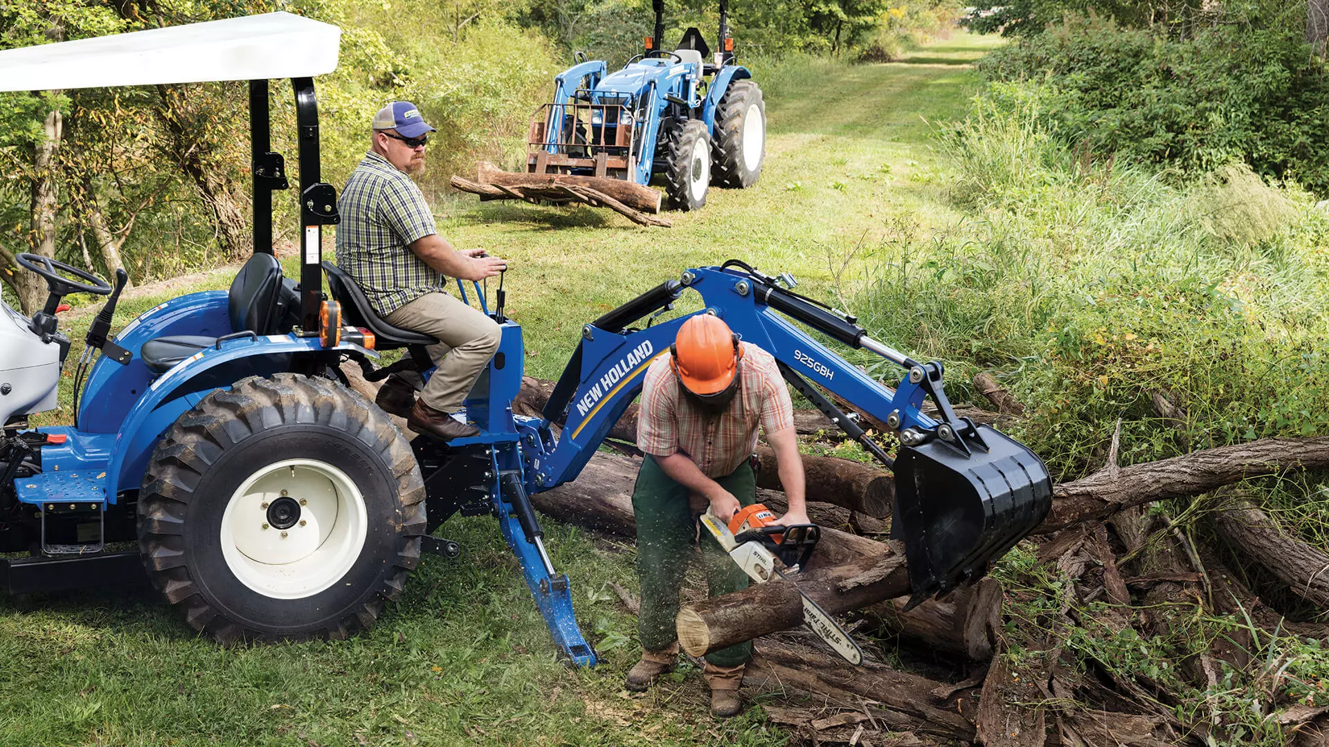 Men move tree trunks using WORKMASTER compact tractor
