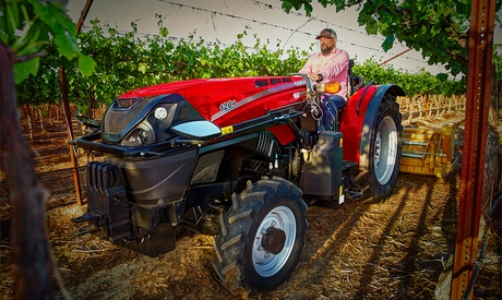 Man operating a Farmall 120N tractor with implement