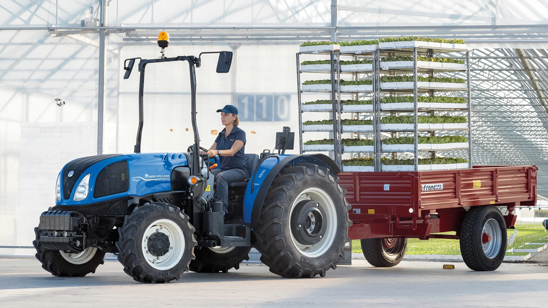 Farming tractor New Holland T3F/LP with mounted trailer in transport duty on farm