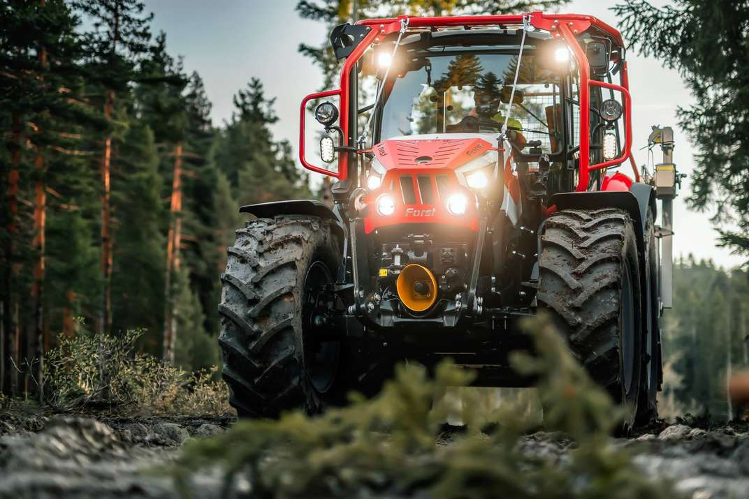 Trattore Forestry STEYR Plus rosso in un bosco