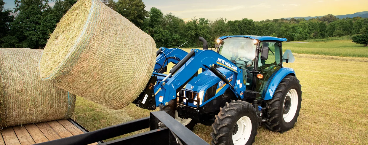 T5 tractor holding up a bale