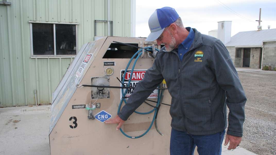 Man pointing to a compressed natural gas sticker on a methane pump.